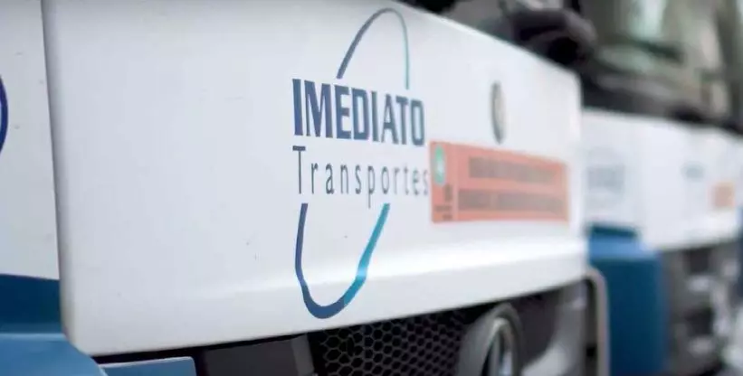 A foto mostra a frente de um caminhão com o logotipo do Grupo Imediato