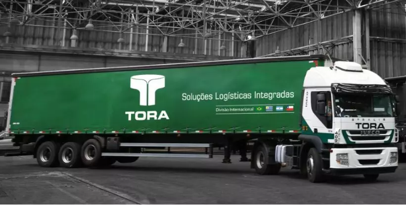 A foto mostra uma carreta da Tora Soluções Logísticas Integradas dentro de um galpão
