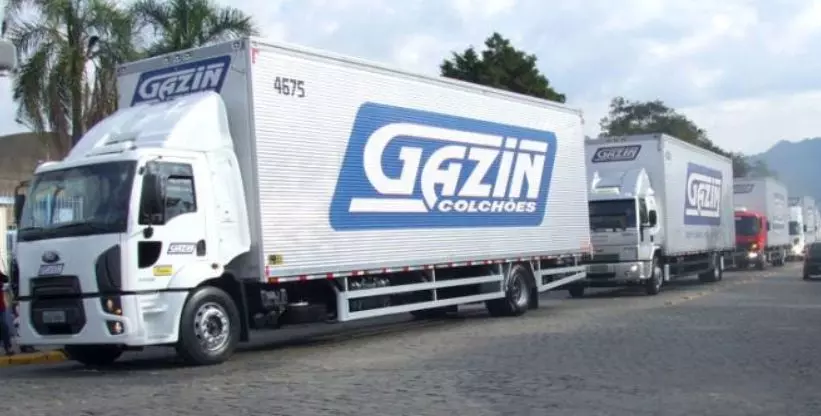 A foto mostra dois caminhões da empresa Gazin