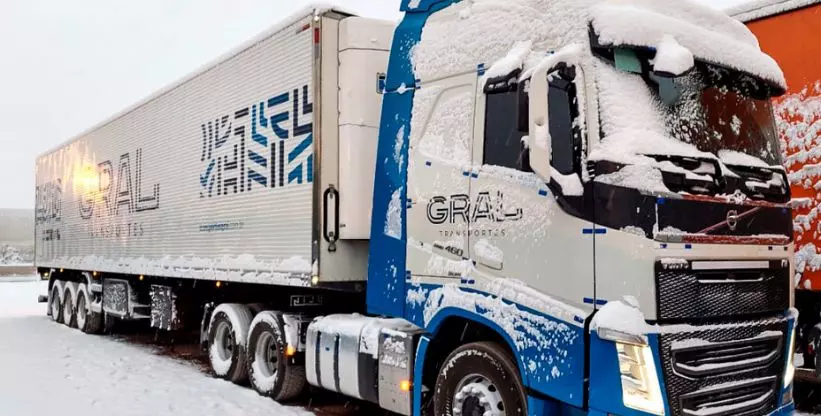 A foto mostra uma carreta da Gral Transportes coberta por neve