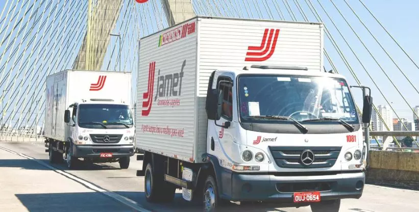 A foto mostra 2 caminhões da caminhões da Jamef Encomendas Urgentes