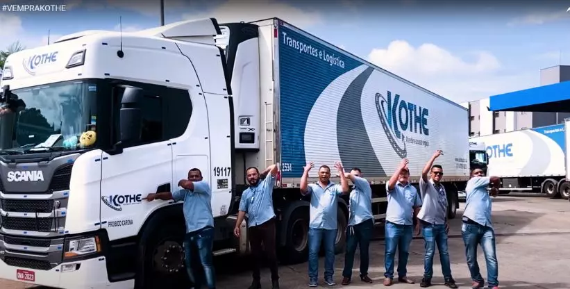 A foto mostra uma carreta e 7 funcionários da Kothe Transportes chamando as pessoas para trabalhar na Kothe
