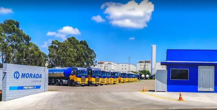 A foto mostra a portaria 2 da empresa Morada Logística e a frota no pátio