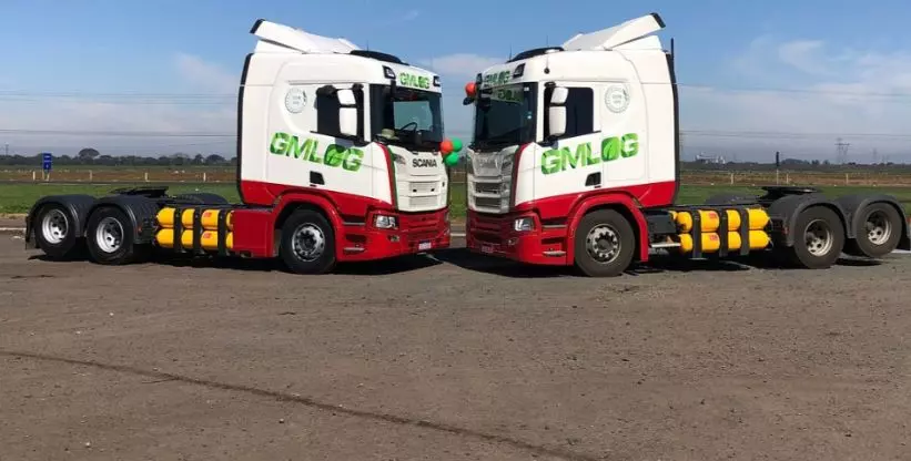 A foto mostra dois caminhões da GMLOG Transportes