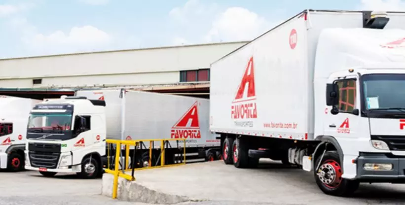 A foto mostra um caminhão e uma carreta da Favorita Transportes