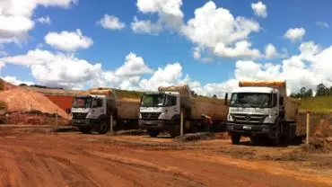 A foto mostra três caminhões da Construtora Vale Verde