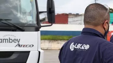 A foto mostra um caminhão e um motorista da Log20 Logística