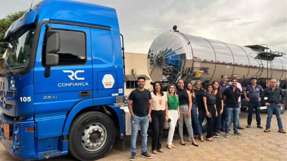 A foto mostra uma carreta da Rodoviário Confiança e vários funcionários da empresa